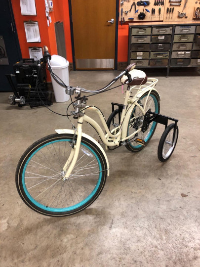 beige bike with training wheels